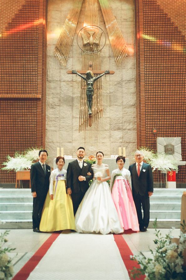 성당 제단 앞 신랑 신부와 양가 가족 사진