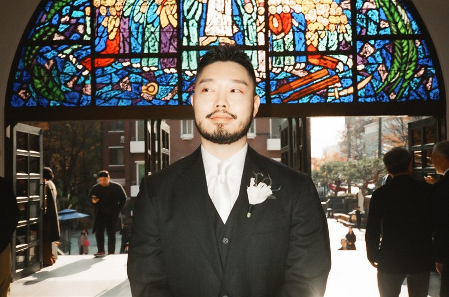 스테인드글라스 아래에서 하늘을 올려다보는 신랑